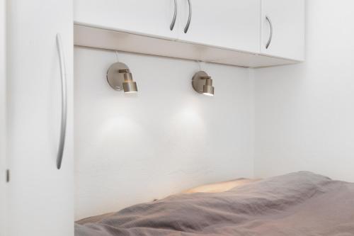 a bedroom with a bed and a white wall at 400 meter til Åen - Moderne og fuldt udstyret in Aarhus