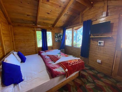 a bedroom with a bed in a wooden cabin at Poppy Resorts Auli in Joshīmath