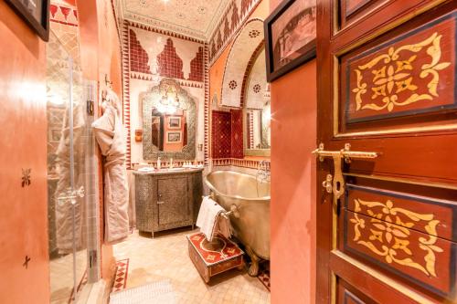 un baño con bañera y lavabo en Riad Hikaya, en Marrakech