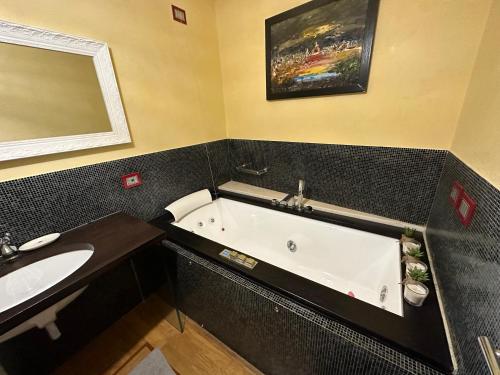 a bathroom with a bath tub and a sink at In Centro Lovely Home in Lucca