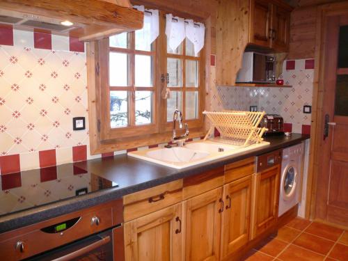 una cucina con un lavandino e una finestra di Spacieux T6 avec jacuzzi, sauna et jardin près des commerces et pistes au Grand-Bornand Village - FR-1-467-89 a Le Grand-Bornand