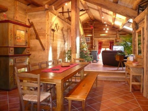 une salle à manger avec une table et des chaises en bois dans l'établissement Spacieux T6 avec jacuzzi, sauna et jardin près des commerces et pistes au Grand-Bornand Village - FR-1-467-89, au Grand-Bornand