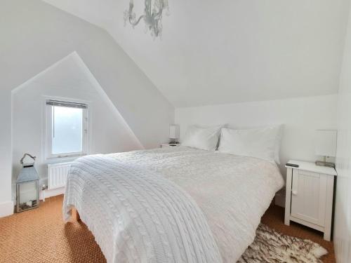 a white bedroom with a bed and a window at West Hill Retreat Seaview Balconette Loft Apartment with Free Parking in Hastings