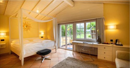 una camera con letto, scrivania e finestra di Albergo Losone a Losone