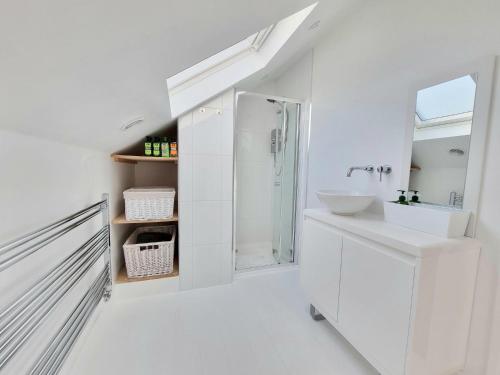 a white bathroom with a sink and a shower at West Hill Villa Retreat - Seaview Balcony Loft Apartment with Breakfast & Free Parking in Hastings