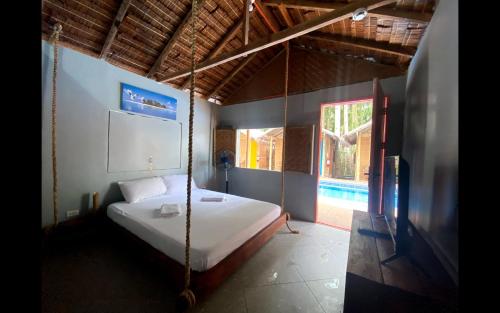 sypialnia z łóżkiem huśtawkowym i oknem w obiekcie The Bangka Beach Guesthouse w mieście Siquijor