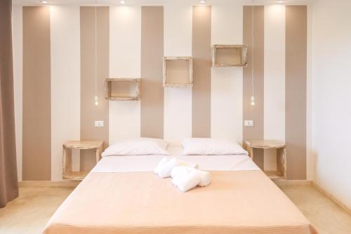 two beds in a room with striped walls at Blue and Blue in Torre San Giovanni Ugento