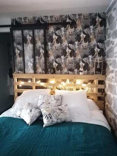 une chambre avec un lit avec des draps blancs et des oreillers dans l'établissement Charmant appartement de village, à Pennautier