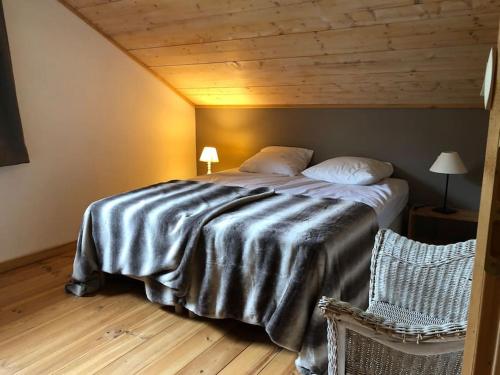 a bedroom with a large bed with a wooden ceiling at Chalet cosy et confortable in Savoie