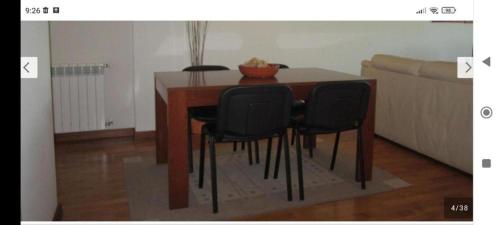 ヴィラ・ノヴァ・デ・ガイアにあるPorto Gaia Beach Apartのダイニングルームテーブル(黒い椅子、ソファ付)