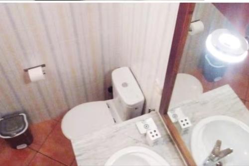 La salle de bains est pourvue de toilettes blanches et d'un lavabo. dans l'établissement Rialza, à Petra