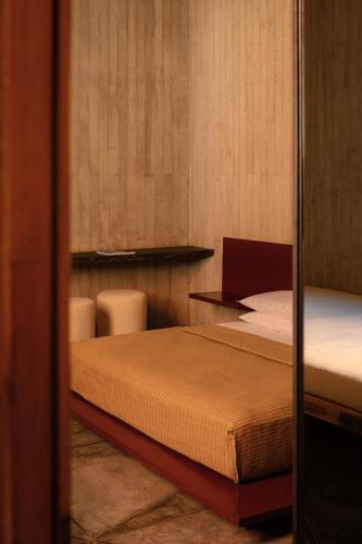 a bedroom with a bed and two chairs in it at Otro Oaxaca, a Member of Design Hotels in Oaxaca City