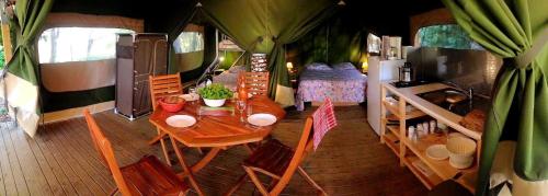 einen Tisch und Stühle im Wohnzimmer eines Campers in der Unterkunft CAMPING LA PIBOLA in Camon