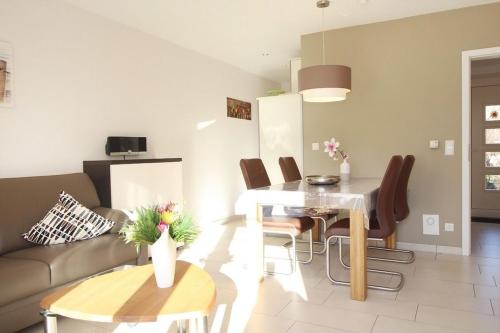 ein Wohnzimmer mit einem Sofa und einem Tisch in der Unterkunft Dünenhäuser Haus 3 in Boltenhagen