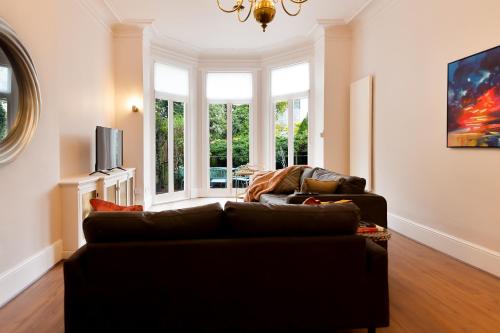 a living room with a couch and a window at Primrose Hill Apartments in London