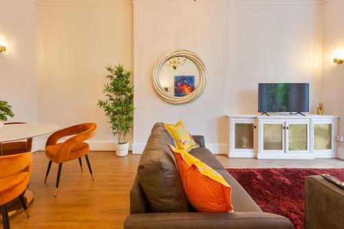 a living room with a couch and a tv at Primrose Hill Apartments in London