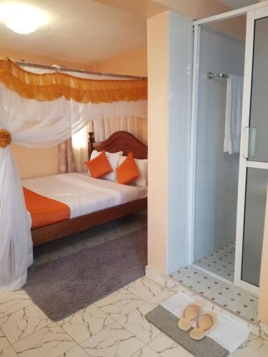 - une chambre avec un lit et quelques sandales au sol dans l'établissement Allamanda Gardens Resort, à Nakuru