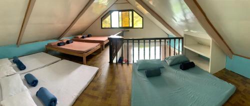Habitación en el ático con 2 camas y balcón en Banaue Transient House Bed and Breakfast en Banaue