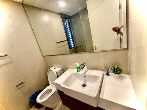 une salle de bain avec un lavabo, des toilettes et un miroir dans l'établissement KL Eco City Apartment by Homeizing, à Kuala Lumpur