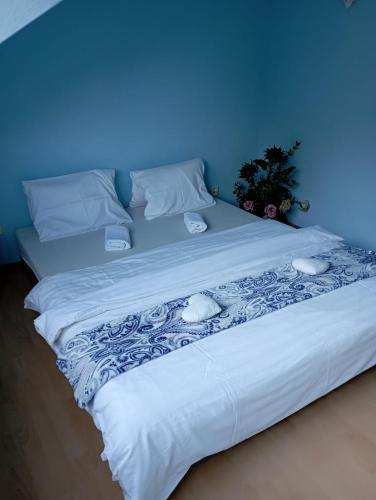 a large white bed with a blue wall at Penzion Jáchymov Pod Lanovkou in Jáchymov