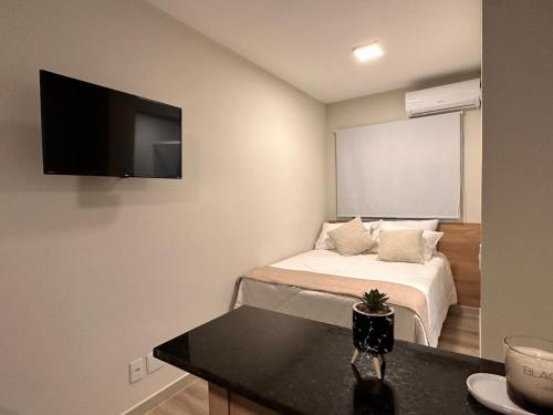 a bedroom with a bed with a flat screen tv on the wall at Apê Brooklin -Berrini in São Paulo