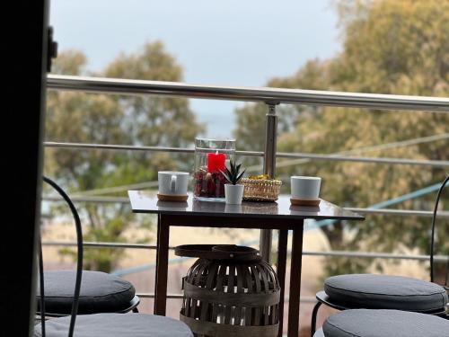 a table with two cups and a candle on a balcony at Villa INTERMEZZo 11 sea view in Neoi Epivates