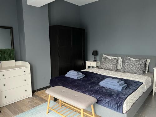 a bedroom with a bed with a blue blanket and a chair at Villa INTERMEZZO 11 sea view in Neoi Epivates