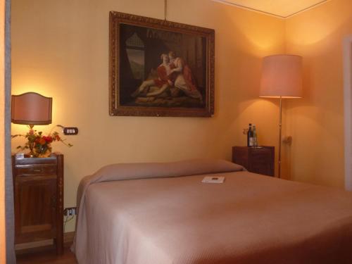a bedroom with a bed and a painting on the wall at B&B Casa Forster in Cannero Riviera