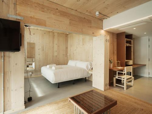 a bedroom with a bed and a tv and a table at Hotel Amiuka in O Pedrouzo