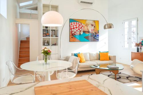 ein Wohnzimmer mit einem weißen Tisch und einem Sofa in der Unterkunft Le Filatiers - incroyable loft aux Carmes in Toulouse