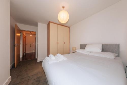 um quarto com uma grande cama branca e uma luz em Exhilarating 2BD Flat with Outdoor Patio Dublin! em Dublin
