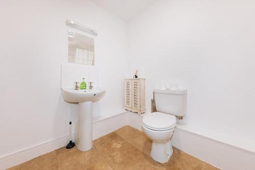 uma casa de banho branca com um WC e um lavatório em Exhilarating 2BD Flat with Outdoor Patio Dublin! em Dublin