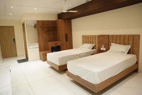 um quarto de hotel com duas camas e uma casa de banho em HOTEL MKR GRAND em Kottapeta