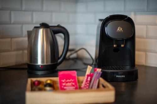 affeepot et une cafetière sur un comptoir avec un plateau en bois dans l'établissement ROBESPIERRE - Tout équipé & Calme - TV et WIFI, à Saint-Étienne