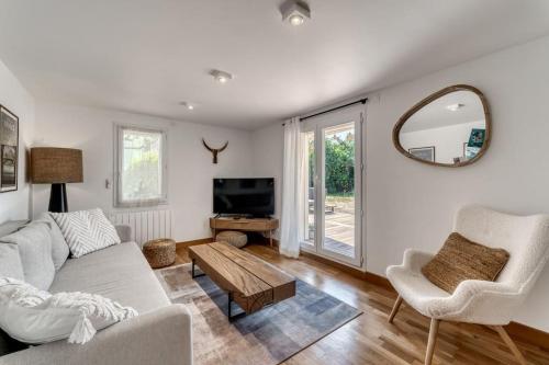 a living room with a couch and a table and a mirror at Appartement chaleureux à Sévrier in Sévrier