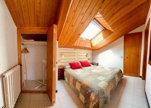 um quarto com uma cama e um tecto de madeira em Petit estudi em Ribes de Freser