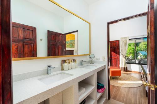 łazienka z 2 umywalkami i dużym lustrem w obiekcie Drake Bay River View w mieście Bahía Drake