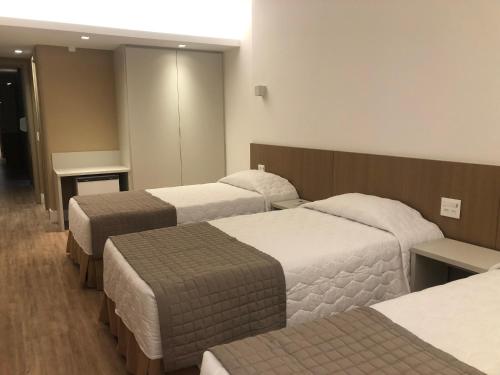 a hotel room with three beds in a room at South American Copacabana Hotel in Rio de Janeiro