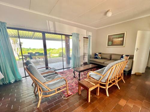 ein Wohnzimmer mit einem Sofa, Stühlen und einem Tisch in der Unterkunft St Lucia Holiday Cottage in St Lucia