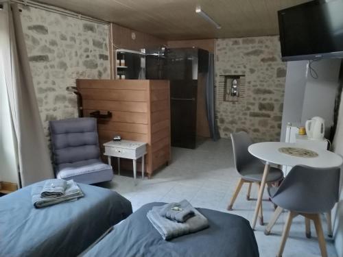 een kamer met 2 bedden, een tafel en een keuken bij Chambre gîte du Gardoir in Boresse-et-Martron