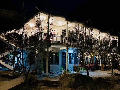 dom oświetlony nocą z drzewami przed w obiekcie Rare House w mieście Kalgha