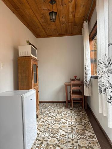 a kitchen with a refrigerator and a table in a room at Nosso Chalet in Lavras Novas
