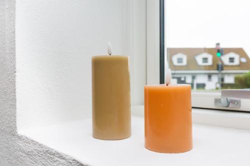 two candles are sitting on a window sill at Moderne & Fuldt udstyret lejlighed m.plads til 4 in Højbjerg