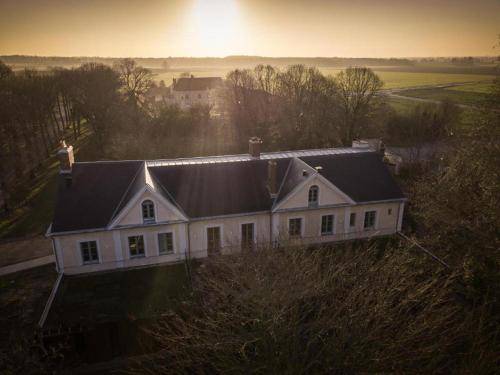 une maison blanche avec un toit noir sur une colline dans l'établissement Mercure Parc du Coudray - Barbizon, à Le Coudray-Montceaux