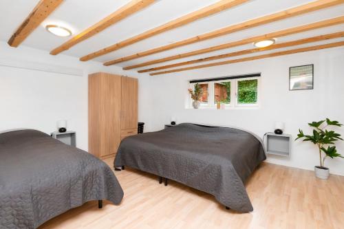 Duas camas num quarto branco com tectos em madeira em Moderne & Fuldt udstyret lejlighed m.plads til 4 em Højbjerg