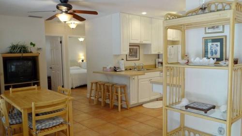 a kitchen with white cabinets and a table and a tv at Street South House #54587 in Bradenton Beach