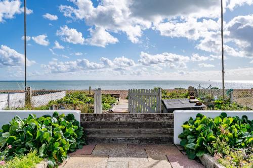 a patio with a view of the beach at Fisherman's Croft Your Dream Getaway Awaits in Pevensey