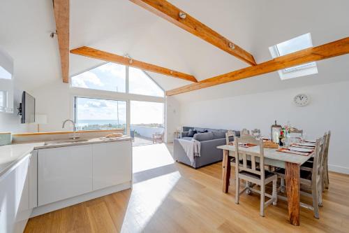 a kitchen and living room with a table and a couch at Fisherman's Croft Your Dream Getaway Awaits in Pevensey