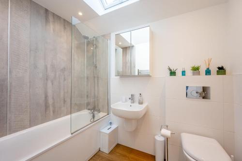 a white bathroom with a shower and a sink at Fisherman's Croft Your Dream Getaway Awaits in Pevensey