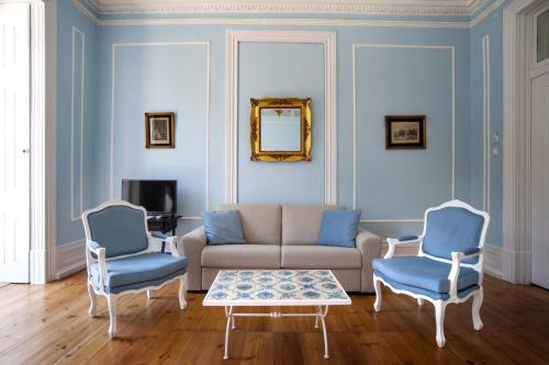 a living room with a couch and two blue chairs at Casa do Principe in Lisbon